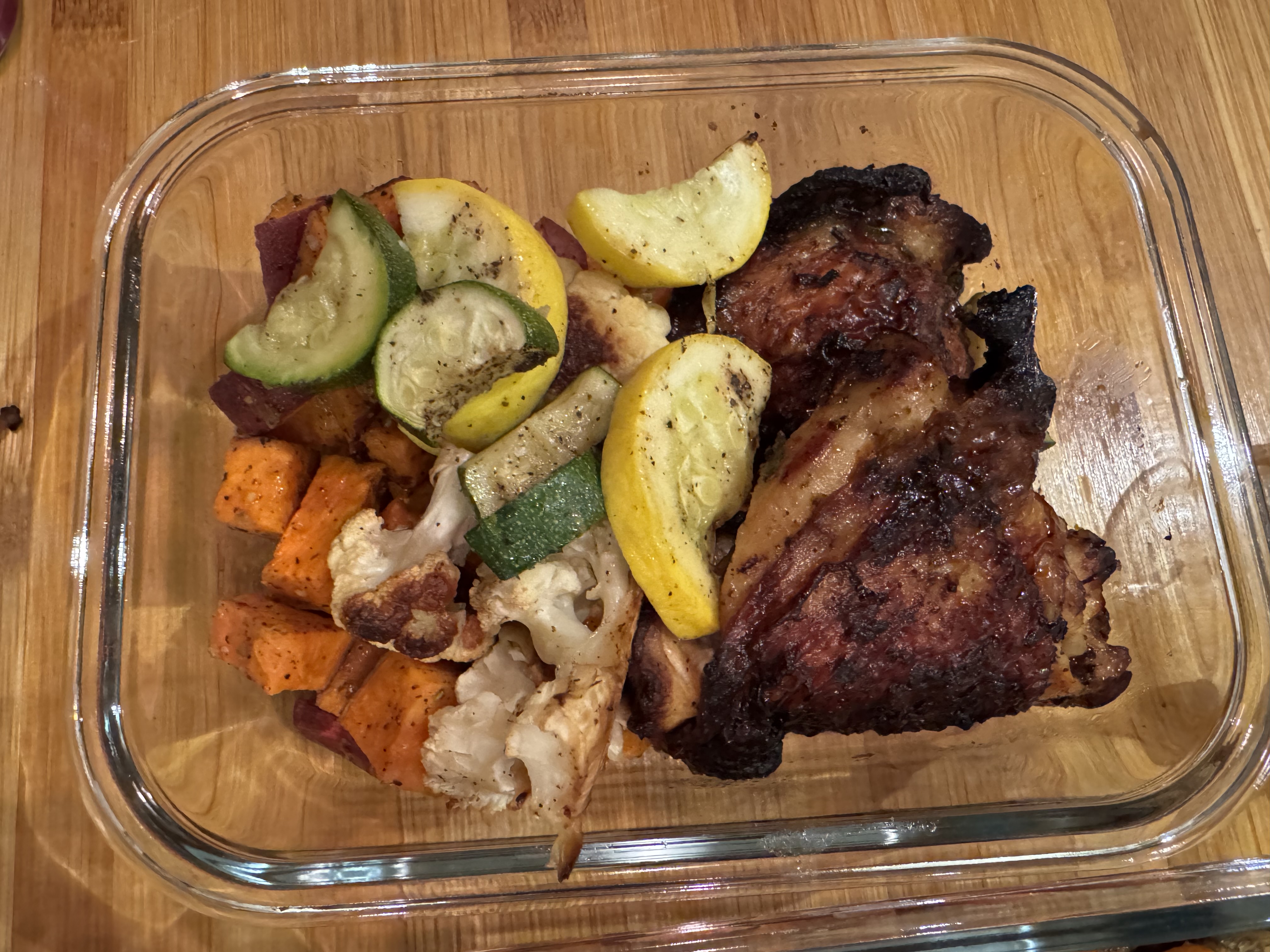 Grilled chicken thighs over sweet potatoes and roasted veggied